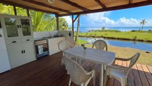 a table and chairs on a deck with a view of the ocean at Fare Horue teahupoo in Teahupoo