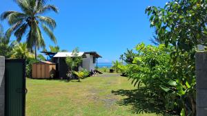 a yard with a house and a palm tree at Fare Horue teahupoo in Teahupoo +7 photos