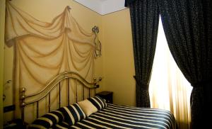 Hotel Regina في بينيرولو: غرفة نوم بسرير مع مظلة