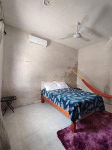 a bedroom with a bed and a ceiling fan at La Casa de la Ría in Río Lagartos
