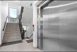 a hallway with a metal door and stairs at Central City Apartment in Svolvær
