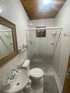 a bathroom with a toilet and a sink and a shower at Casa da Vica in São Gabriel