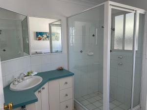 a white bathroom with a sink and a shower at Fishing Haven Holiday Park in Palmers Island +88 photos