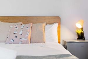 悉尼Classic Double Room - Quaint Place in South Hurstville - Shared Bathroom的卧室里有一张床，床头板是木制的，枕头也是木制的