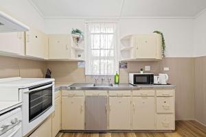 a kitchen with white cabinets and a sink at Serene Double Room - Cozy hideaway in South Hurstville - Shared Bathroom in Sydney +28 photos