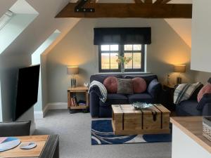 a living room with a blue couch and a tv at Woodland View in Richmond