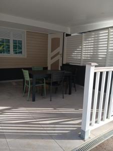 a patio with a table and chairs in front of a house at Bas de Villa - Nid d’amour in Rivière-Salée +1 photo
