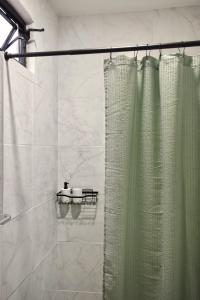 a shower with a green shower curtain in a bathroom at Departamento Apolo in Jamay