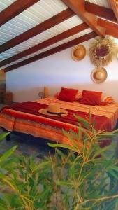 a bedroom with a bed with red pillows at Tidododesiles in Bouillante