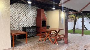 eine Terrasse mit einem Tisch und einem Steinofen in der Unterkunft Apartamento em Porto de Galinhas in Porto De Galinhas