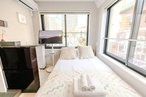 a bedroom with a bed and a large window at Shinjuku iotele-hatsudai House in Tokyo