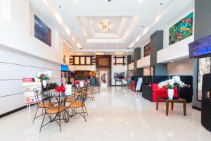 マニラにあるHotel Sogo Santolanの椅子・テーブル・花の店ロビー