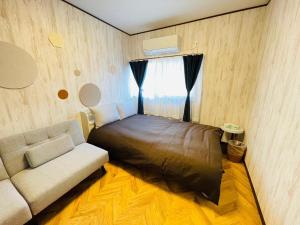 a small bedroom with a bed and a couch at Koguma Shizuka in Osaka