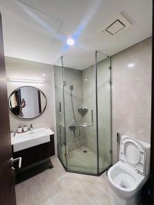 a bathroom with a shower and a toilet and a sink at Luxury Apartment M1 Masteri- Vinhomes Ocean Park 1 in Gia Lâm Pho