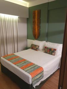 a bedroom with a bed with white sheets and pillows at Olímpia Beach Park Ap e Ingressos in Olímpia