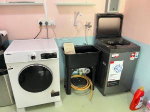 a washing machine and a dryer in a room at Hippo House Taiping in Taiping