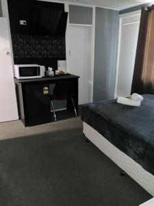 een hotelkamer met een bed en een magnetron bij Commercial Hotel Werris Creek in Werris Creek +6 foto's