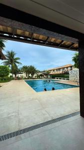 a swimming pool with two people in the water at Vacation House Geribá in Búzios