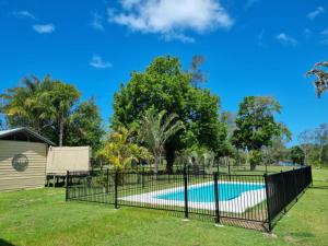 a fence around a swimming pool in a yard at Riverside Farm Stay in Pelican Island