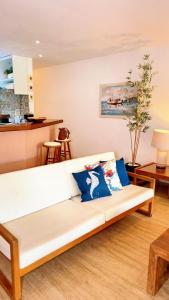 a white couch in a living room with blue pillows at Vacation House Geribá in Búzios +52 photos
