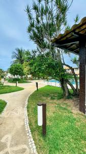 a park with a tree and a path next to a beach at Vacation House Geribá in Búzios