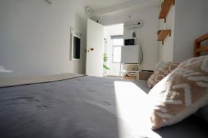 a white room with a bed and a television at Rock’s Beach Spot Suit in Costa da Caparica
