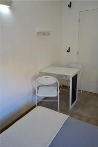 a room with a table and a chair and a desk at Rock’s Beach Spot Suit in Costa da Caparica +8 photos