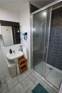 a bathroom with a shower and a sink at Rock’s Beach Spot Suit in Costa da Caparica
