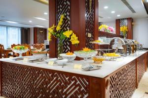 a buffet line with bowls of food in a restaurant at Au Lac Ha Long Hotel in Ha Long