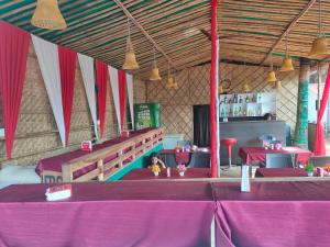 a dining room with purple tables and red curtains at Love paradice huts in Arambol +66 photos