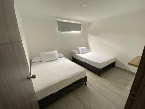 a small room with two beds and a window at Apartamento en ulloa in Ulloa