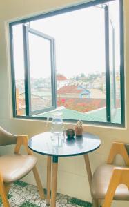 a table and two chairs in a room with a window at Chất home in Da Lat