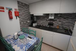 a small kitchen with a table and a table and chairs at Rock's Beach Spot A in Costa da Caparica