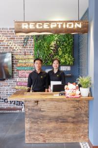 two people standing at a reception counter at a restaurant at The G Hotel Hue in Hue