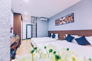 a hotel room with two beds and flowers at The G Hotel Hue in Hue +52 photos