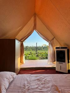 The Lake Farm - Dak Lak في بون ما توت: سرير في خيمة مطلة على ميدان