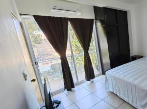 a bedroom with a bed and a large window at Casa los niños in Bucerías