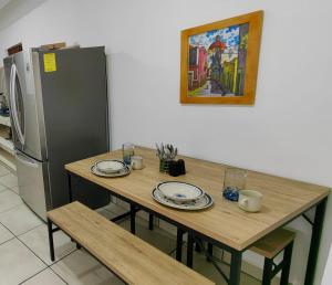 a table with plates and a refrigerator in a kitchen at Casa los niños in Bucerías