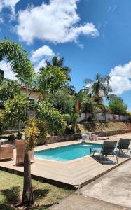 ein Pool in einem Garten mit zwei Stühlen daneben in der Unterkunft Chácara D'M in Santa Isabel