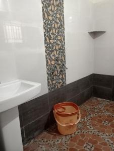 a bathroom with a bucket next to a sink at hope villa homestay gokarna in Gokarna