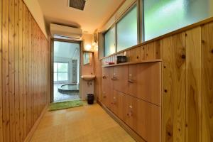 a hallway with wood paneling and a large window at KKR Kinosaki Genbu in Kinosaki