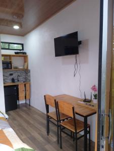 a kitchen and dining room with a table and chairs at Arenal Tiny Lodge #1 in San Francisco