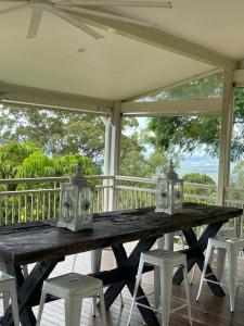 a wooden table on a screened porch with chairs at Emirau in Montville