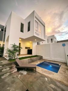 a white house with a swimming pool in front of it at Casa Japandi in Manta