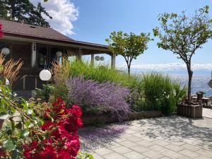 a house with flowers and a view of the water at Blitz Beach House Oceanside Suite in Powell River