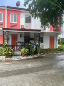 a red and white house with red doors and plants at Compostela Two Story Richwood Townhome Breakfast Offered in Compostela +30 photos