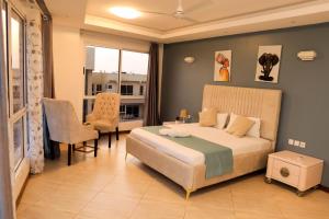 a bedroom with a bed and a table and a chair at Antalyia Luxury Apartments Nyali in Mombasa +78 photos