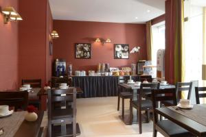 a restaurant with tables and chairs and a bar at Hôtel Orchidée in Paris