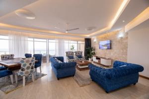 a large living room with blue chairs and a table at Antalyia Luxury Apartments Nyali in Mombasa