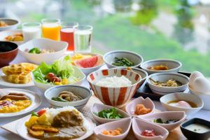 a table topped with bowls and plates of food at Hotel Seifuuen in Shibata